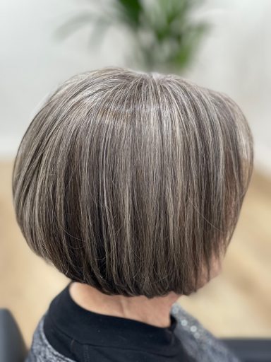 Pelo corto con un corte bob gris con reflejos en un fondo interior claro.