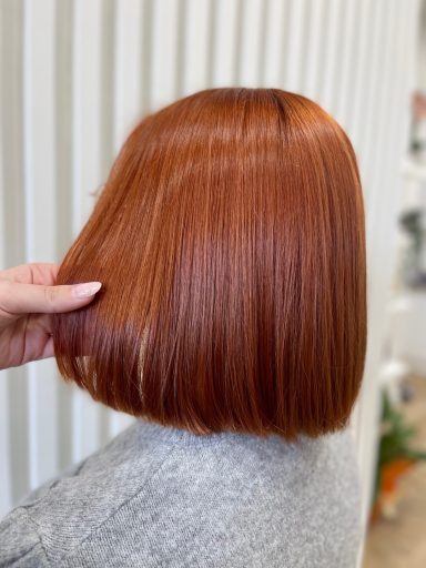 Mujer con cabello corto y recto de color rojo brillante.